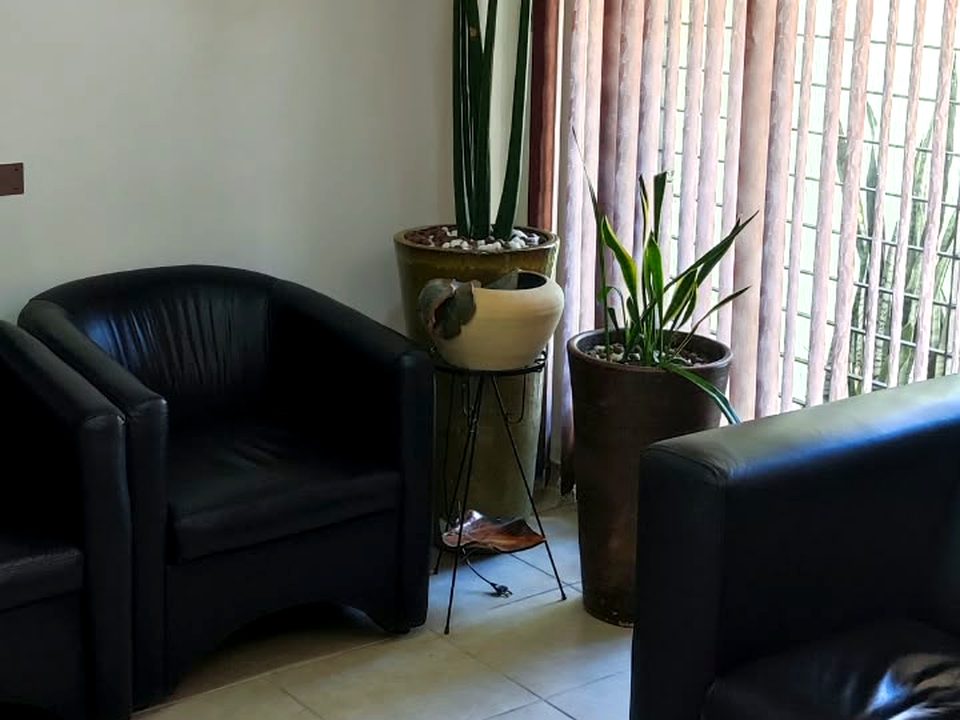 Recepção da clínica com poltronas e plantas