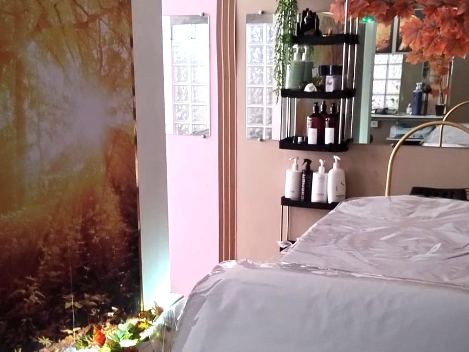 Sala de terapia capilar com maca e painel decorativo