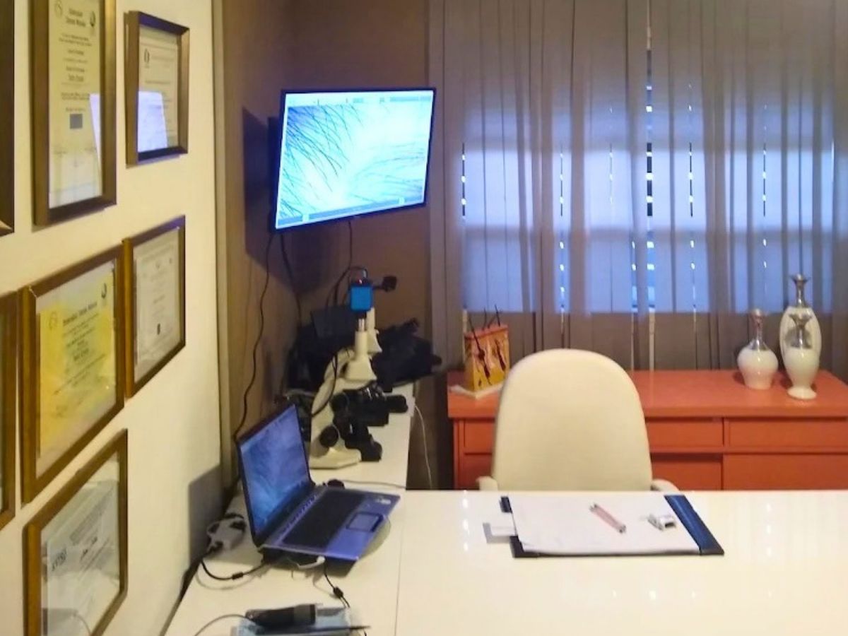 Sala de avaliação capilar com microscópio, monitor de tricoscopia e certificados